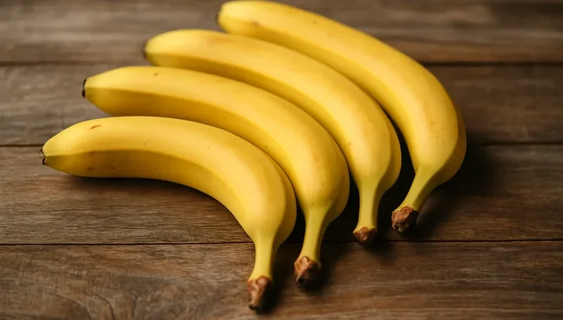 Pet svežih banana na drvenoj podlozi – brz i prirodan izvor energije, bogat kalijumom i jednostavnim ugljenim hidratima.